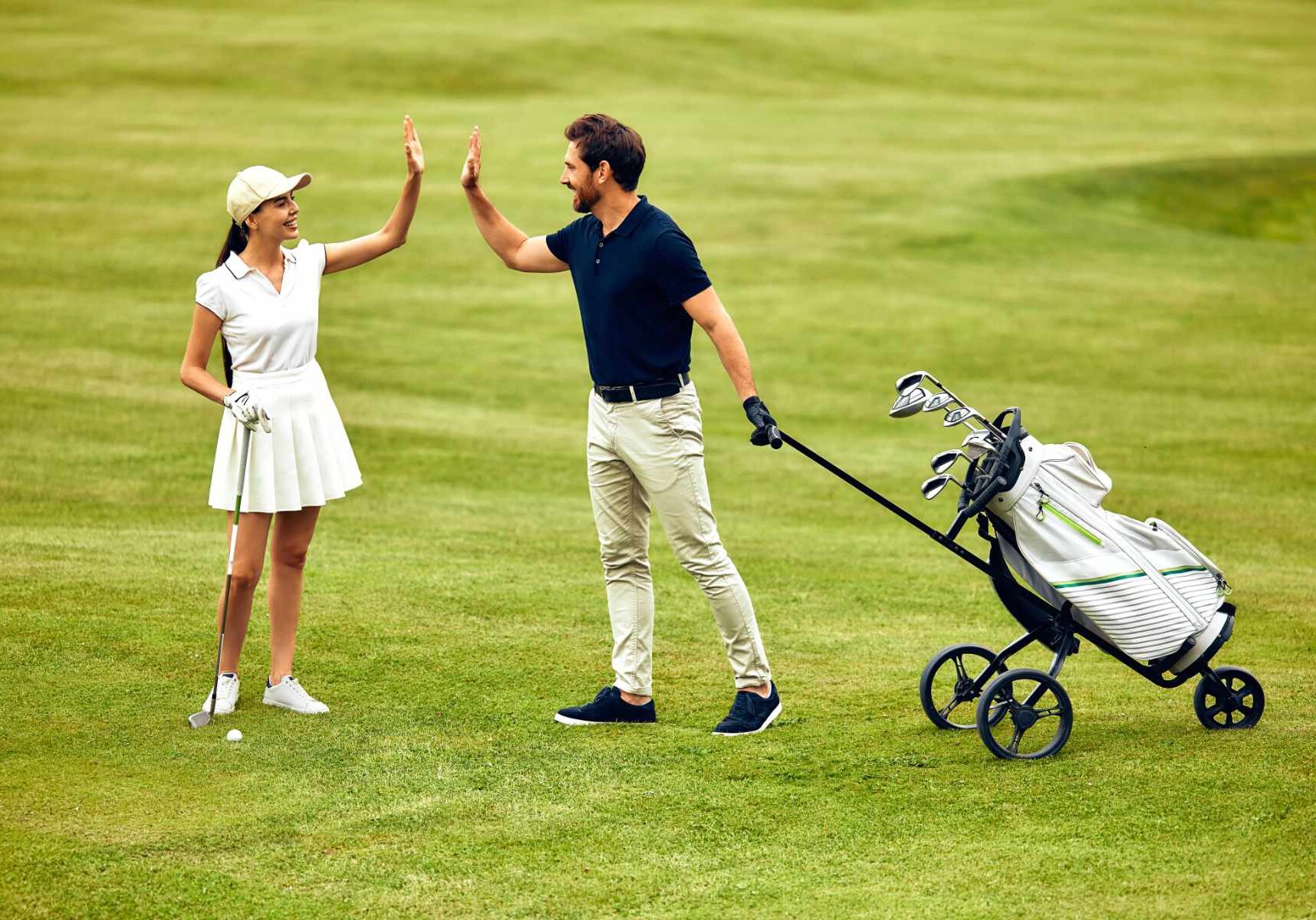 An enthusiastic group of golfers joyfully share a highfive on a lush, green golf course, perfectly embodying the spirit of camaraderie and happiness that prevails in the vibrant sports community